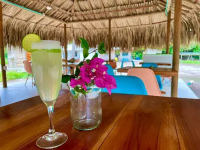 a glass of champagne and a vase with a flower on a table at Hotel Las Casitas De Mar Adentro in Isla Grande