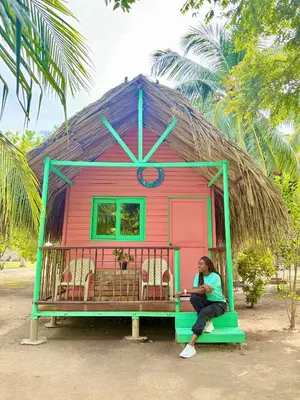a woman sitting on a bench in a play house at Hotel Las Casitas De Mar Adentro in Isla Grande