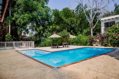 a swimming pool with a table and an umbrella at Hotel Restaurante Selva Negra in Turbaco
