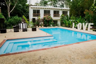 a swimming pool in front of a house at Hotel Restaurante Selva Negra in Turbaco