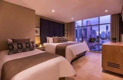 a hotel room with two beds and a large window at Oz Hotel Luxury in Cartagena de Indias