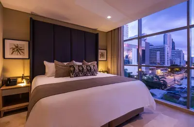 a bedroom with a large bed and a large window at Oz Hotel Luxury in Cartagena de Indias