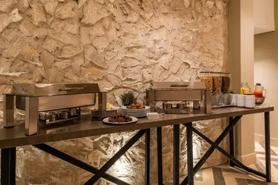 a table with food on it in front of a stone wall at Oz Hotel Luxury in Cartagena de Indias