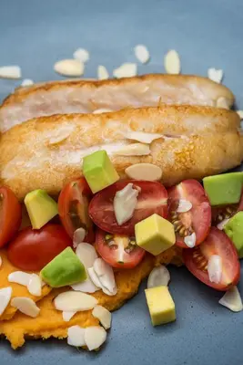 a hot dog with tomatoes and cheese on a bun at Oz Hotel Luxury in Cartagena de Indias