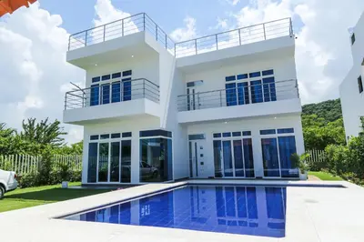 a house with a swimming pool in front of it at VILLA MANDALAY in Santa Veronica