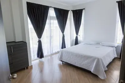 a bedroom with a bed and a large window at VILLA MANDALAY in Santa Veronica