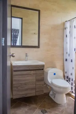 a bathroom with a toilet and a sink and a mirror at VILLA MANDALAY in Santa Veronica