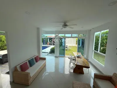 a living room with a ceiling fan and a table at VILLA MANDALAY in Santa Veronica