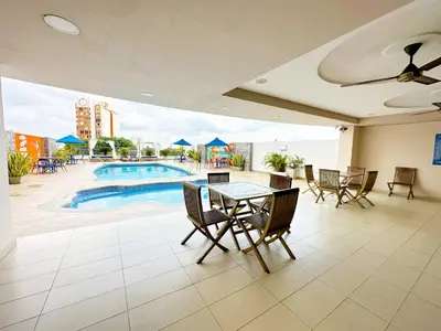 a patio with a table and chairs and a pool at Howard Johnson by Wyndham Barranquilla Versalles in Barranquilla