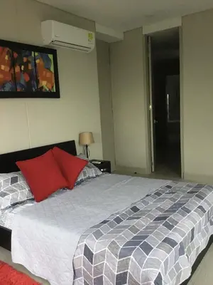 a bedroom with a bed with a red pillow at Martinique1621 in Cartagena de Indias