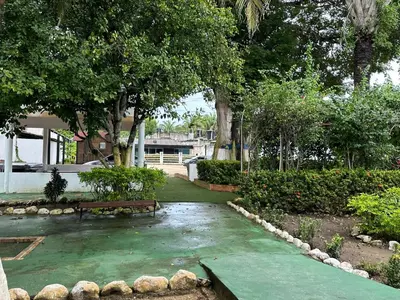 a park with a bench and trees and a house at Apartamento en Coveñas cómodo y acogedor in Coveñas