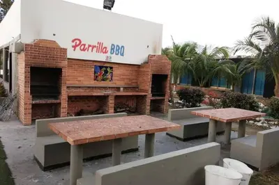 two picnic tables in front of a brick building at Apartamento en Coveñas cómodo y acogedor in Coveñas