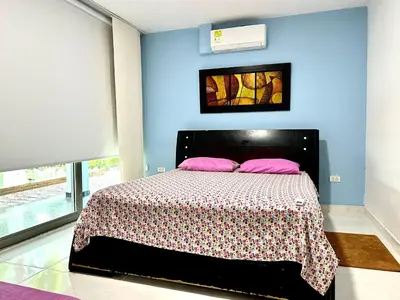 a bedroom with a bed with pink pillows on it at Apartamento en Coveñas cómodo y acogedor in Coveñas