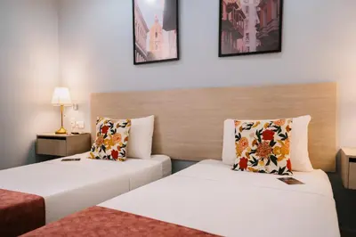 a hotel room with two beds and a couch at Casa Franco Hotel in Cartagena de Indias