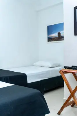 a bedroom with two beds and a tv on a table at Neos Hotel Cartagena in Cartagena de Indias