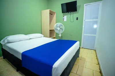 a blue and white bed in a room with a fan at Neos Hotel Cartagena in Cartagena de Indias