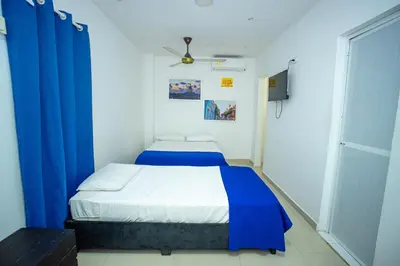 a small room with a bed with blue curtains at Neos Hotel Cartagena in Cartagena de Indias