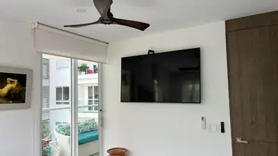 a ceiling fan and a flat screen tv on a wall at Spiaggia Morros Direct Beach Access in Cartagena de Indias