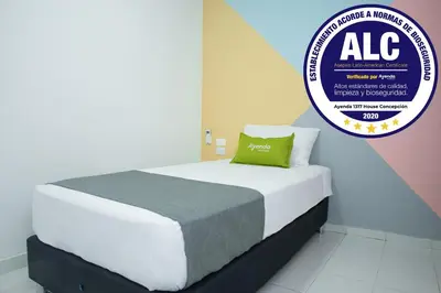 a bed in a room with a aac sign above it at Hotel Ayenda House Concepción 1317 in Barranquilla