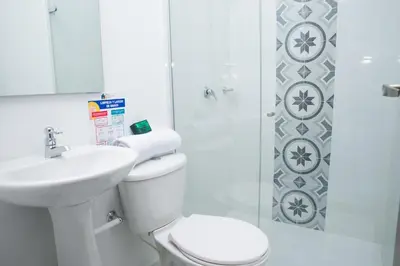 a bathroom with a toilet and a sink and a shower at Hotel Ayenda House Concepción 1317 in Barranquilla