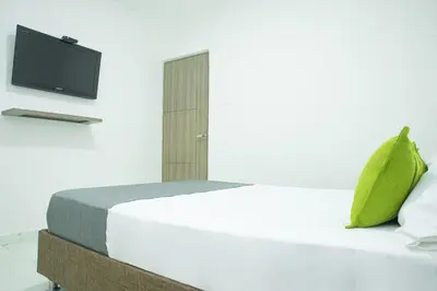 a bedroom with a bed with a tv on the wall at Hotel Ayenda House Concepción 1317 in Barranquilla