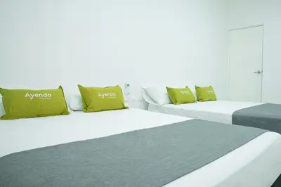 two beds sitting next to each other in a room at Hotel Ayenda House Concepción 1317 in Barranquilla