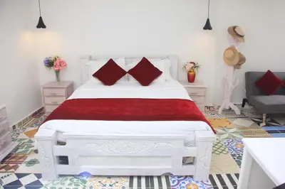 a bedroom with a white bed with red pillows at Casa St James in Cartagena de Indias