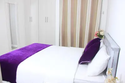 a bedroom with a bed with a purple blanket and pillows at Casa St James in Cartagena de Indias