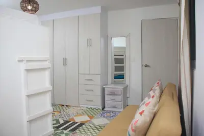 a small room with a bed and a closet at Casa St James in Cartagena de Indias