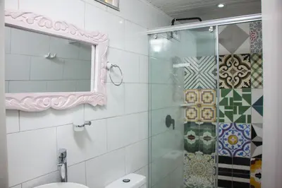 a bathroom with a shower and a toilet and a mirror at Casa St James in Cartagena de Indias