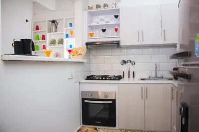 a kitchen with white cabinets and an oven at Casa St James in Cartagena de Indias