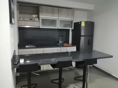 a kitchen with a black counter and a refrigerator at Berilo Deluxe Apartahotel in Barranquilla