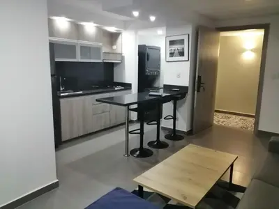 a kitchen with a black table and a refrigerator at Berilo Deluxe Apartahotel in Barranquilla