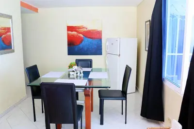 a dining room with a table and chairs and a refrigerator at 2 Alcoves Beachfront 2-19C air-wifi in Cartagena de Indias