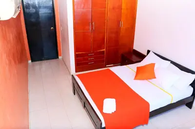a bedroom with a bed with an orange pillow at 2 Alcoves Beachfront 2-19C air-wifi in Cartagena de Indias