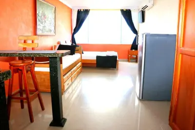 a room with a bed and a table and a refrigerator at Loft sea view 11C air and wifi in Cartagena de Indias