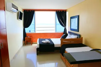 a hotel room with two beds and a window at Loft sea view 19C air and wifi in Cartagena de Indias