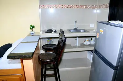 a kitchen with a refrigerator and a counter with two stools at Loft sea view 19C air and wifi in Cartagena de Indias