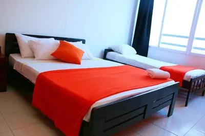 a bedroom with two beds with orange and white pillows at Sea View Apartment 1-19C Air Wifi in Cartagena de Indias