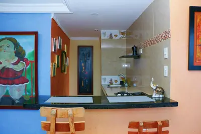 a kitchen with a counter and two chairs in it at Sea View Apartment 1-11C air wifi in Cartagena de Indias