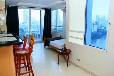 a bedroom with a bed and a desk and a window at Sea View Apartment 1-11C air wifi in Cartagena de Indias