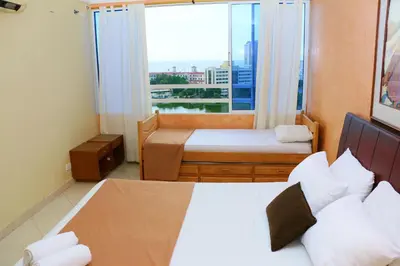 a bedroom with two beds and a large window at Sea View Apartment 1-11C air wifi in Cartagena de Indias