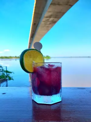 a drink sitting on a table with an orange slice at Hotel Campestre Maguey in Mangue