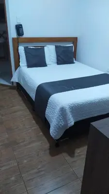 a bedroom with a large bed with blue pillows at Hotel Campestre Maguey in Mangue