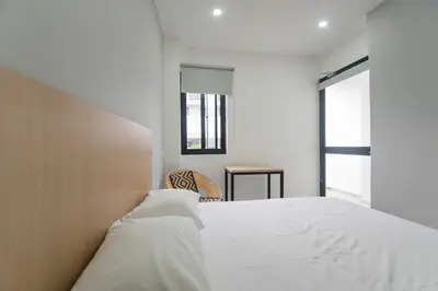 a bedroom with a white bed and a chair at Stanza Hotel Sincelejo in Sincelejo