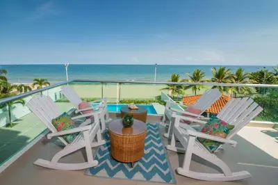 a balcony with chairs and a table and the ocean at Mágico Apartamento Frente al Mar 3 Habitaciones PV21 in Coveñitas
