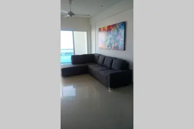 a black couch in a living room with a painting at Cartagena De Indias in Cartagena de Indias