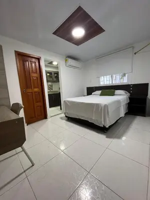 a bedroom with a bed and a chair in it at Villa Santos Apartaestudios in Barranquilla