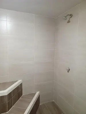 a bathroom with a shower with a bench and a shower at Hotel Torre del Prado in Barranquilla