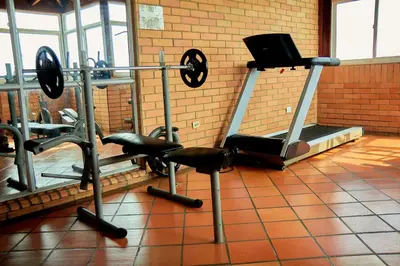 a gym with tread machines and a tv on a rack at Hotel Torre del Prado in Barranquilla